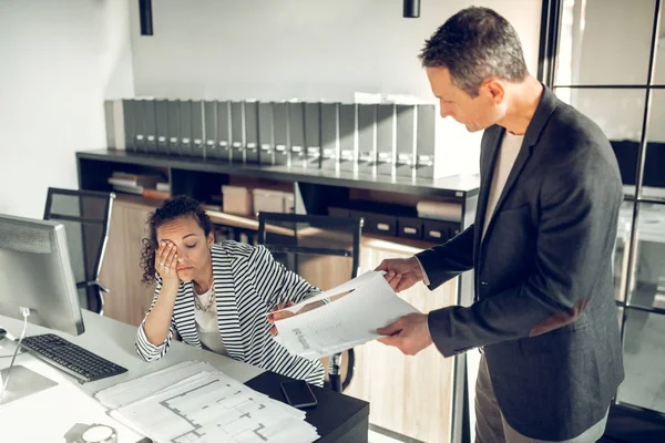 Secretaria morena sintiéndose cansada y soñolienta hablando con el jefe — Foto de Stock