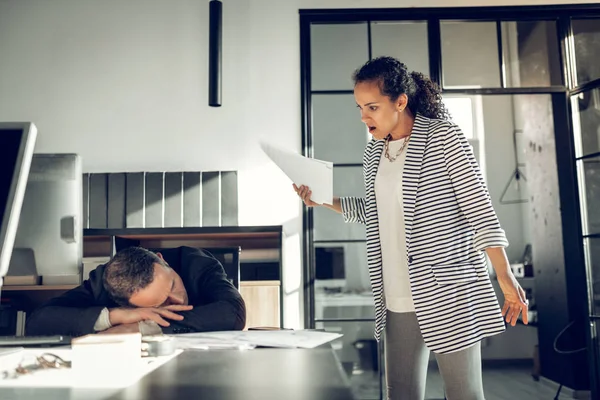 Businesswoman feeling shocked watching her employee sleeping