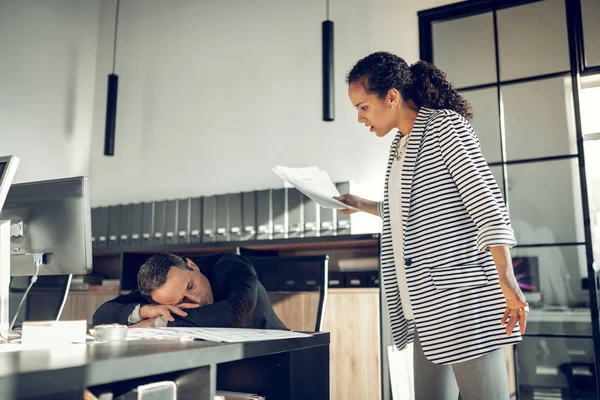 Стильна бізнес-леді дивиться на свого помічника сплячого — стокове фото