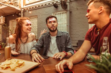 Bir hedbanz oyunu oynarken contended adamlar