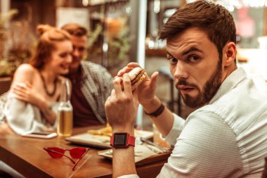 Arkadaşları sarılarak kıskançlık hisseden bir adamın portresi