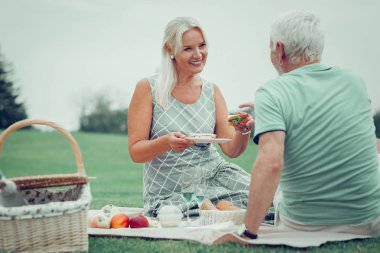 Sandviç ile bir plaka tutan mutlu güzel bir kadın