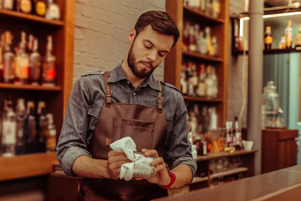 Guapo cantinero puliendo un vaso en el bar —  Fotos de Stock