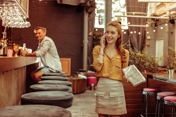 Encantadora dama teniendo una conversación telefónica en el bar . — Foto de Stock