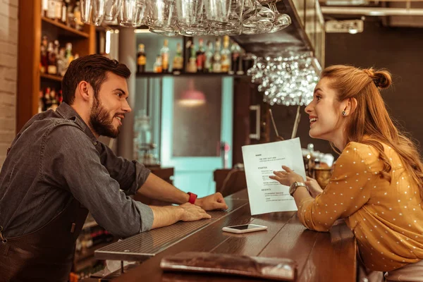 Ведьма, обсуждающая меню с красивым темноволосым бородатым барменом — стоковое фото