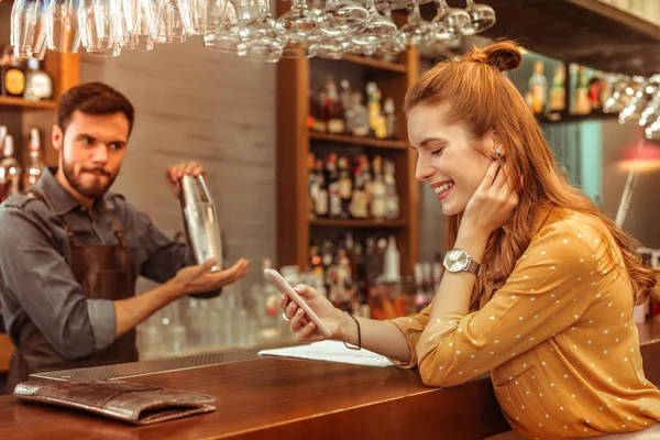 Lycklig kvinna tittar på telefonen i händerna — Stockfoto