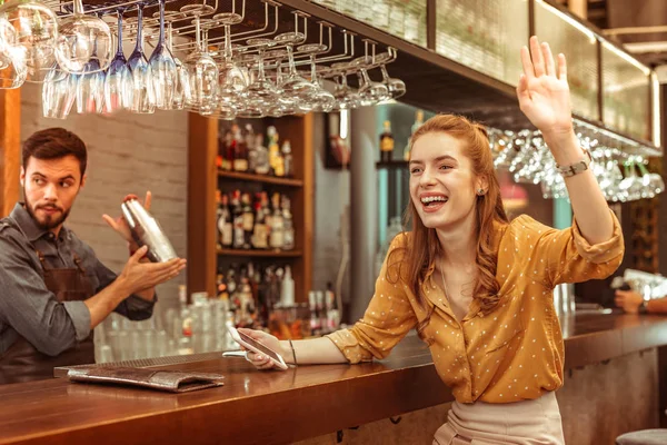 Alegre hermosa pelirroja risueño bar visitante emocionalmente saludando a alguien — Foto de Stock