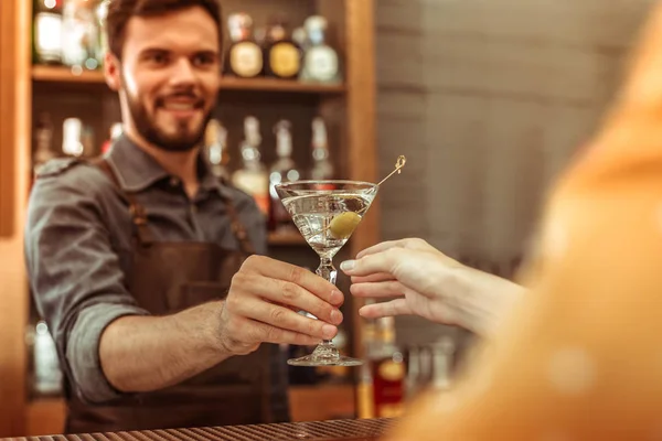 Trabalhador de bar atraente entregando um coquetel martini a um cliente — Fotografia de Stock