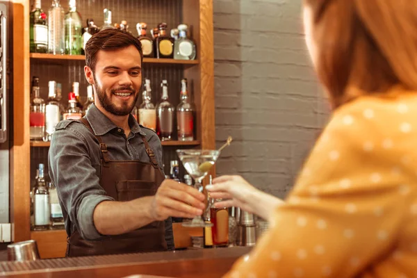 Attraktiver Barkeeper, der einer Frau einen Martini-Cocktail schenkt — Stockfoto