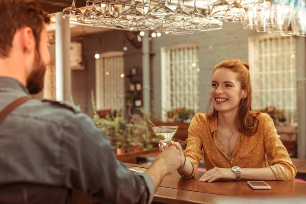 Mulher sorridente tomando um coquetel de martini de um barman — Fotografia de Stock