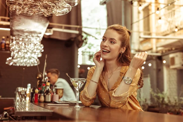 Довгошерста усміхнена сяюча леді насолоджується сидячи в барі — стокове фото
