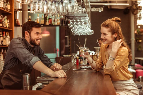 Mujer pelirroja hablando con barman mientras sostiene un cóctel — Foto de Stock