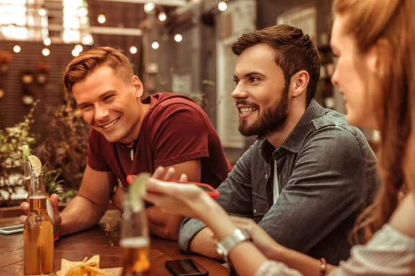 Sonriendo joven-adulto dos hombres sentados en la mesa del bar — Foto de Stock