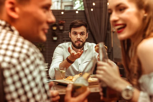 Pohledný muž se cítí osamělý, zatímco jeho přátelé flirtovat — Stock fotografie