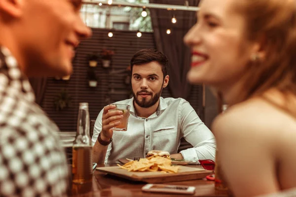 Atractivo y atractivo hombre atractivo mirando a sus amigos coqueteando — Foto de Stock