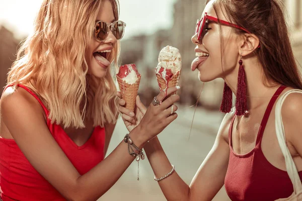 Две красивые привлекательные молодые взрослые чувственные красотки, держащие в руках мороженое — стоковое фото