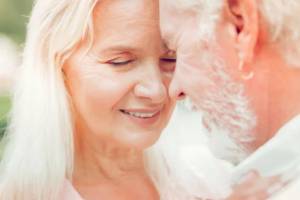 Face av en trevlig äldre kvinna medan kramas hennes man — Stockfoto