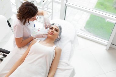 Kozmetoloji kliniğinde güzel bir yetişkin kadın üst görünümü