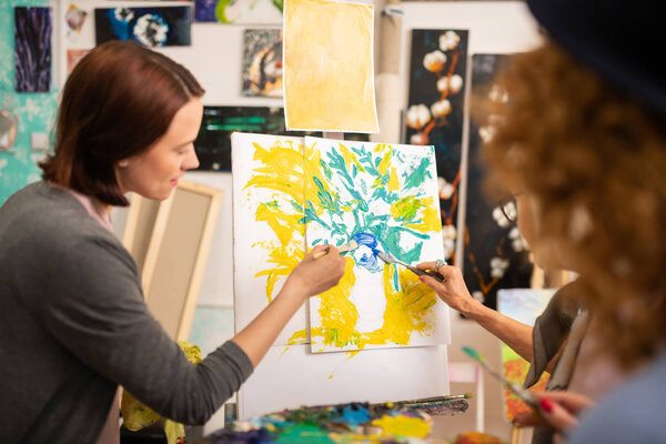 Студенты-художники раскрашивают натюрморты на холсте
