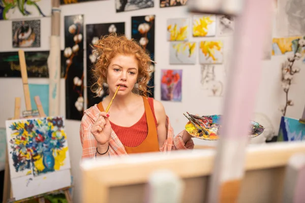 Estudante de arte ruiva sentindo-se envolvido em fazer tarefa em casa — Fotografia de Stock