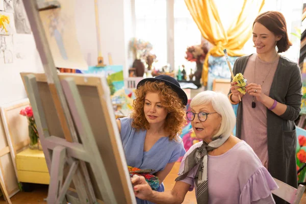 Artist standing behind her aged teacher and friend — Stock Photo, Image