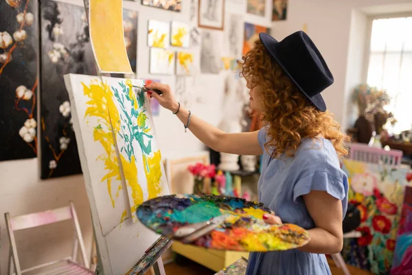 Curly red-haired artist feeling inspired while coloring picture — Stock Photo, Image