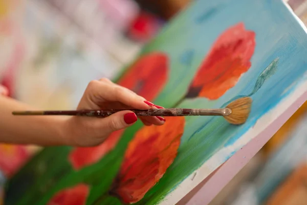 Close up de artista segurando escova e pintando papoilas — Fotografia de Stock