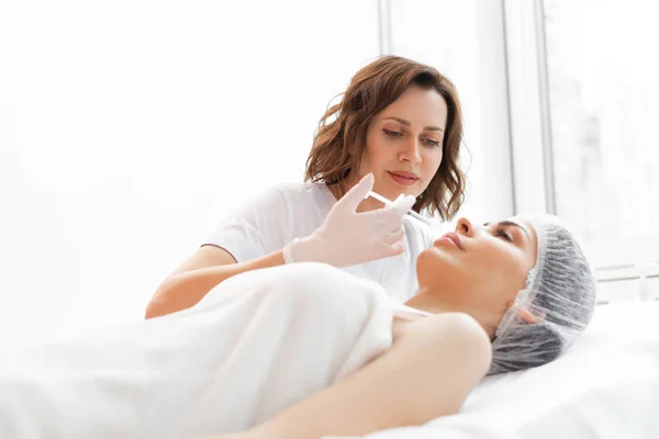 Positive skilled cosmetologist doing a contour plastic