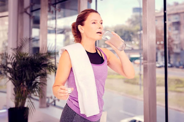 Trött brunett kvinna uppfriskande själv med vatten — Stockfoto