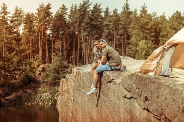 Bir uçurumun üzerinde oturan güzel hoş bir çift