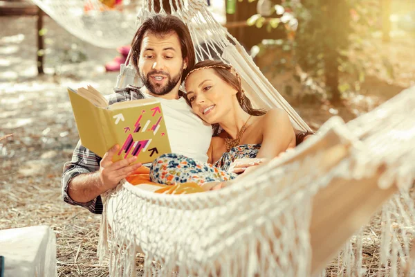 Ωραίος όμορφος άνθρωπος διαβάζοντας ένα βιβλίο με την κοπέλα του — Φωτογραφία Αρχείου