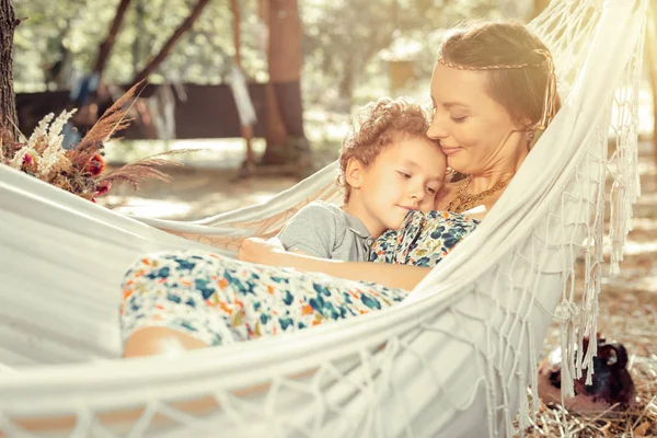 Jovem mulher positiva descansando junto com seu filho — Fotografia de Stock