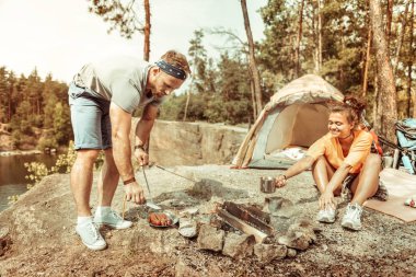 Yakışıklı sakallı adam lezzetli ızgara sosis hizmet