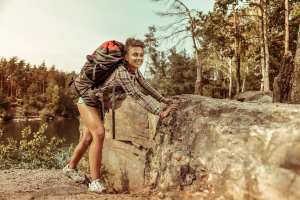 Beautiful positive active woman climbing a cliff — Stock Photo, Image