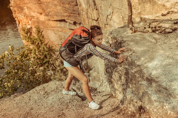 Красивая привлекательная женщина, взбирающаяся на скалу — стоковое фото