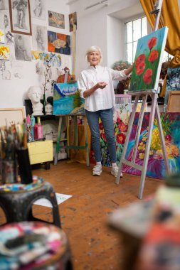 Tablonun yanında duran muhteşem bir kadın.