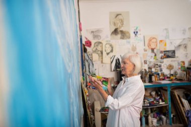 Atölyede çalışan profesyonel yaşlı sanatçı ışınlama
