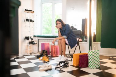 Güzel kadın giyim mağazasında seçim yapmak zor hissediyorum.