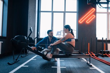 Spor salonunda hafif kilolu olan eğitmen yardımcı kadın