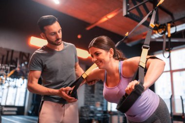 Fitness eğitmeni Trx egzersiz tombul kadın yardımcı