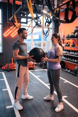 Kilolu kadın antrenör topu alarak tozluk giyiyor