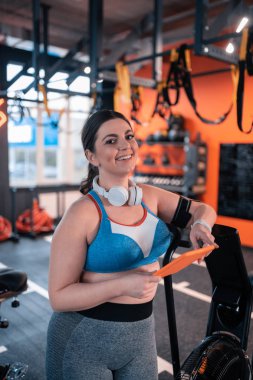 Spor salonunda egzersiz öncesi gülümseyen tombul kadın Işınlama