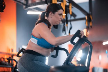 Dolgun kadın spor salonunda bisiklet gerçekten bitkin duygu