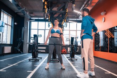 Egzersiz yaparken barbell tutan kilolu kadın