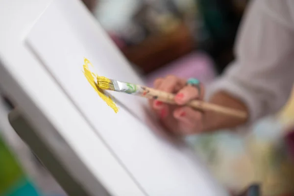 Κοντινό χρώμα πινέλου ζωγραφικής με λαμπερό κίτρινο γουνόπονο — Φωτογραφία Αρχείου