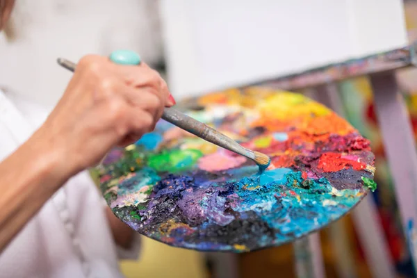 Γυναίκα που κρατά πινέλο ζωγραφικής και χρωματική παλέτα — Φωτογραφία Αρχείου