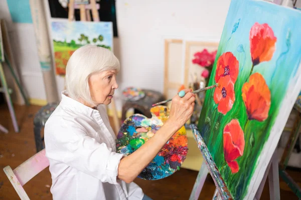 Blond-haired kvinna målning Red Poppies på duk — Stockfoto