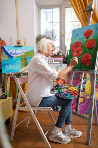 Åldrad kvinna målning på duk i helgen — Stockfoto