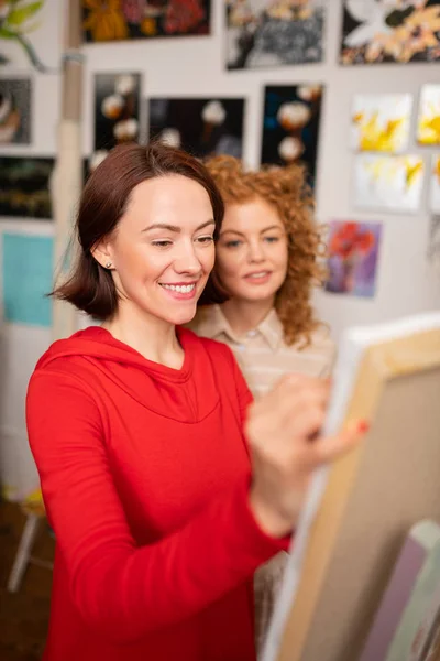 Giovane insegnante d'arte sorridente mentre si avvicina al suo studente — Foto Stock