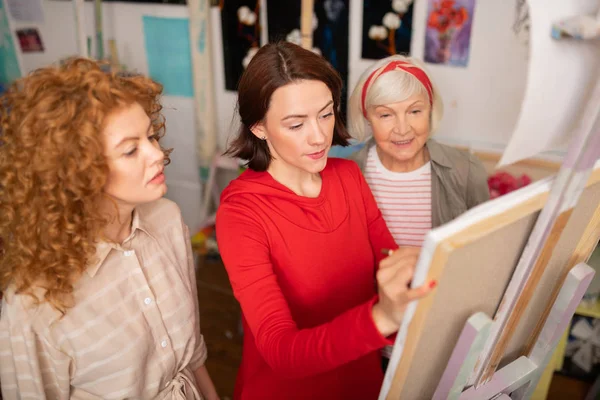 Woman drawing standing near her art tutor and friend — Stock Photo, Image